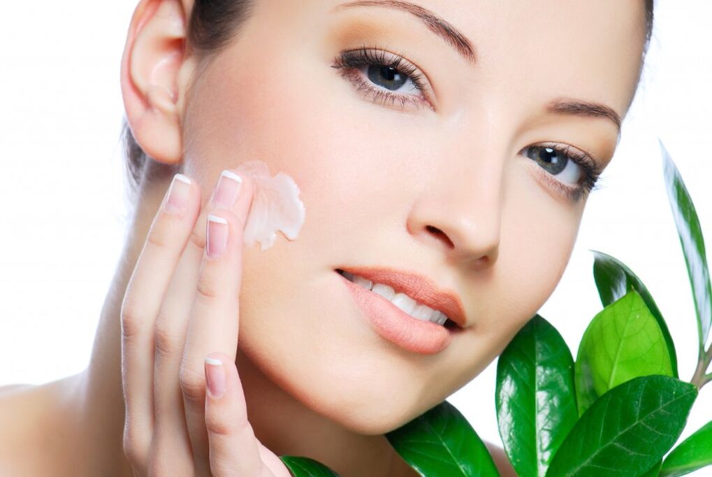 a girl lubricates her face with rejuvenating cream